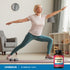 An older woman practices yoga next to a B-Complex bottle, highlighting health and wellness routine.