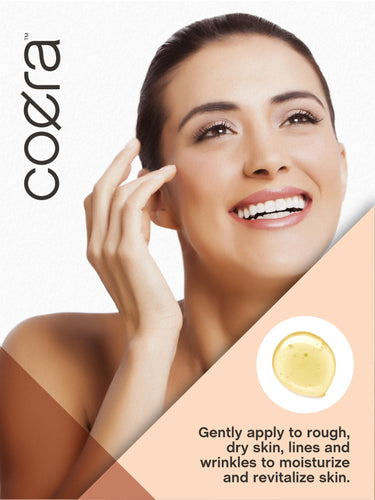 Lifestyle image of adult touching her face with Coera Vitamin E Oil, with text stating Gently apply to rough, dry skin, lines and wrinkles to moisturize and revitalize skin.