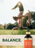 Two young adults perform an acroyoga pose in a sunny park with a Carlyle Potent Hemp Oil bottle.