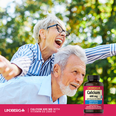 Elderly couple laughing, playing piggyback ride outdoors with a Lindberg Calcium bottle in hand.