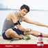 A young adult male stretches outdoors next to a CoQ-10 bottle.