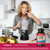 Middle-aged woman sampling a smoothie made with a blender next to a bottle of Complete Digestant.