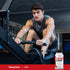 Young man using a rowing machine beside an HMB supplement bottle.