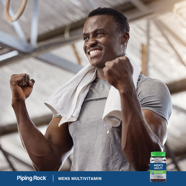 Young man smiling and flexing after a workout, showcasing Men's Multi Gummies in a lifestyle setting.