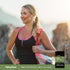 A woman in a black and pink athletic top holds a gym bag and smiles with a bottle of NAD+ Resveratrol, Multi Collagen.