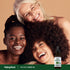 Three diverse women, happy and embracing, holding a bottle of Organic Neem Oil.