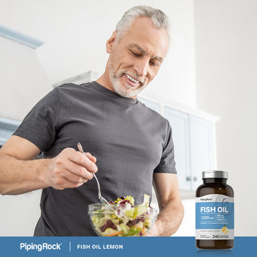 An elderly man prepares a salad next to a bottle of Fish Oil Lemon Softgels, promoting healthy lifestyle choices.