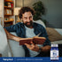 Lifestyle image of man relaxing on a couch while reading a book, with Piping Rock Sublingual B12 Methylcobalamin supplement bottle nearby