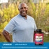 Smiling adult standing outdoors with Lindberg Super Colon Health bottle nearby.