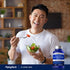 A man enjoys a salad next to a bottle of R-Lipoic Acid.