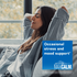 A young woman relaxes on a couch with closed eyes, next to a box of Natural Vitality Maxcalm.