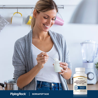 A young woman enjoys yogurt near a bottle of Serrapeptase, suggesting its use as a complement to her meal.