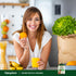 Woman smiling in a kitchen, holding an orange and juice, with Super Fruits & Veggies packaging visible.
