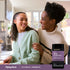 A mother and her teenage daughter smiling together in a kitchen with a bottle of Teen Multi + Probiotics.