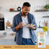 Young adult male enjoying a meal in a kitchen next to a Turmeric Curcumin supplement bottle, illustrating daily use.