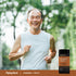 Older man jogging outdoors and smiling while holding a Turmeric+ CoQ10 bottle.