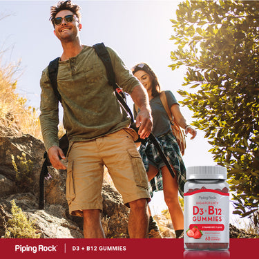 A young man and woman enjoy hiking outdoors while holding a bottle of D3+B12 Gummies.