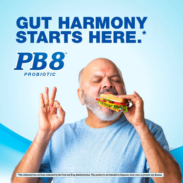 Middle-aged man eats a sandwich while making an 'okay' gesture, accompanied by PB8 Probiotic.