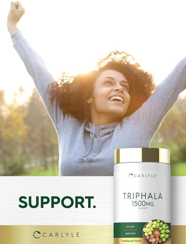 Young woman outdoors smiling with raised arms next to a Triphala bottle.