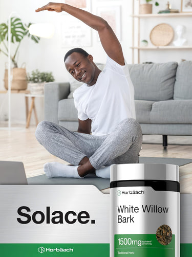 A young adult male stretches on a yoga mat and smiles, next to a bottle of Horbaach White Willow Bark.