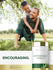 A man plays with a boy on his back in a grassy park, next to an Asparagus extract bottle.