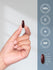 A 1-inch dark red Magnesium Citrate 850mg softgel held in a hand.
