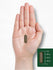 Carlyle Triphala 1500 mg capsule held in a hand, measuring roughly three-quarters of an inch long.