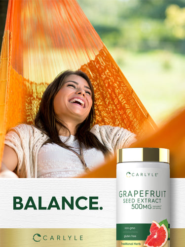 Lifestyle image of a smiling woman relaxing in an orange hammock with Grapefruit Seed Extract 500MG bottle and graphic stating BALANCE.