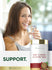 A young woman smiles and drinks water next to a Carlyle Tart Cherry & Celery Seed bottle.