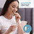 A happy young woman takes a Marine Collagen caplet while holding a glass of water.