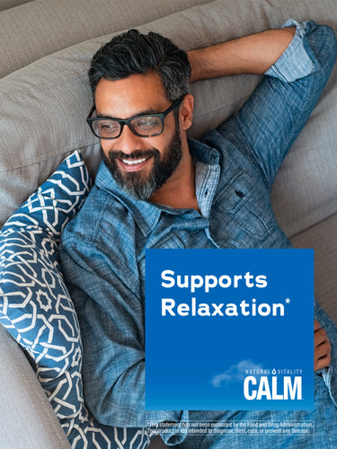A smiling middle-aged man relaxes on a couch with a Natural Vitality Calm product overlay nearby.