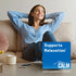 A young woman relaxing on a couch with a box of Natural Vitality Calm nearby.