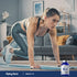 Adult exercising on yoga mat with Piping Rock DMG B-15 supplement bottle nearby