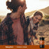 Lifestyle image of two adults hiking outdoors with Piping Rock Turmeric+ Ginger supplement bottle nearby.