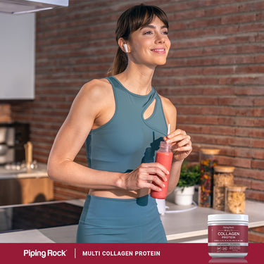 Lifestyle image of woman in activewear holding a smoothie with Piping Rock Multi Collagen Protein bottle nearby