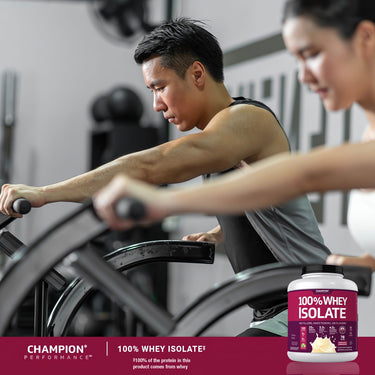 Adults exercising on air bikes in a gym with 100% Whey Isolate whey protein bottle displayed in the foreground