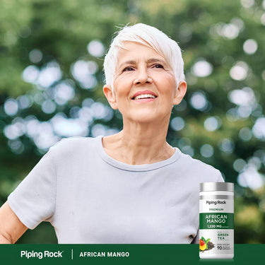 Lifestyle image of older adult outdoors with Piping Rock African Mango supplement bottle nearby.