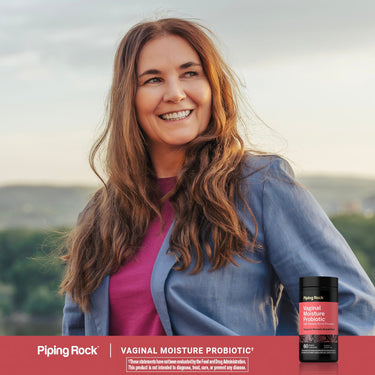 Adult smiling outdoors, with a Piping Rock Vaginal Moisture Probiotic† with Slippery Elm & Pineapple bottle nearby