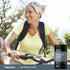 Middle-aged woman biking outdoors with a bottle of Strontium Citrate.