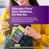 A woman places an Ultimate Flora Probiotic 20 Vegan Capsules blister pack into her black quilted handbag.