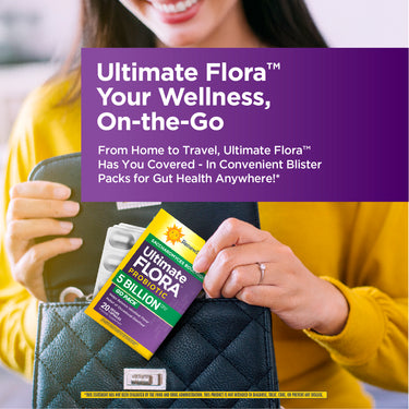 A woman places an Ultimate Flora Probiotic 20 Vegan Capsules blister pack into her black quilted handbag.
