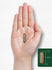 A translucent brownish-gold capsule, approximately 3/4 inch long, is held in an open hand.